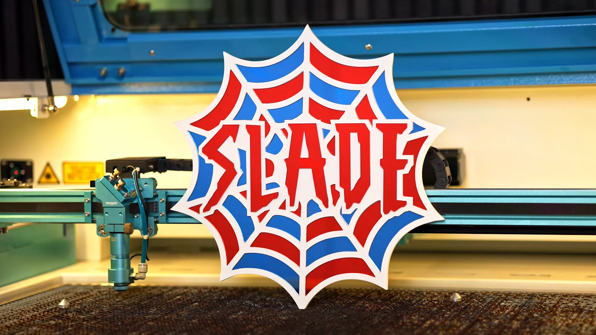 Layered laser cut acrylic sign with custom name lettering shown inside a laser cutting machine