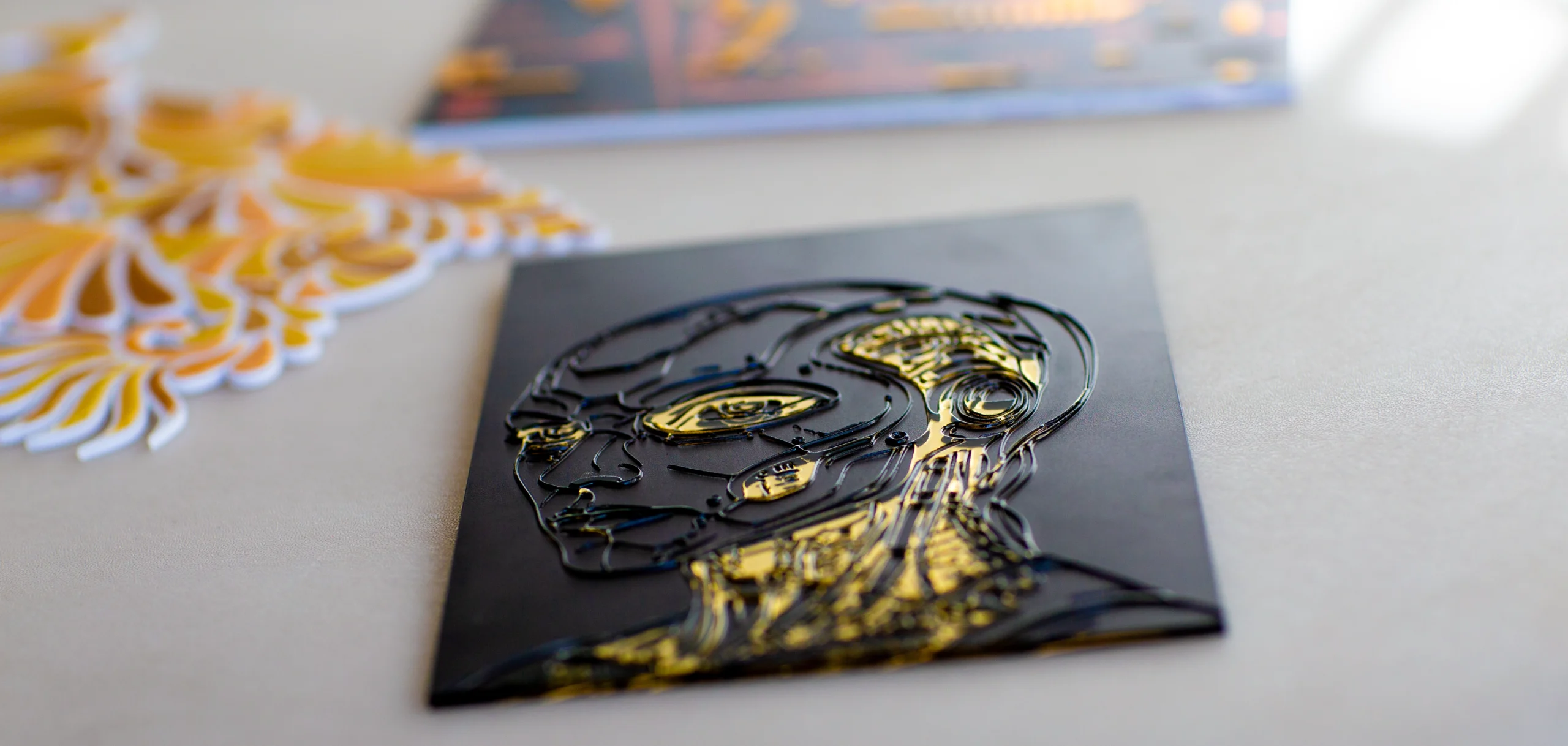 Close-up of a robotic portrait on gold mirror acrylic showing reflective gold areas and raised UV-printed detail.