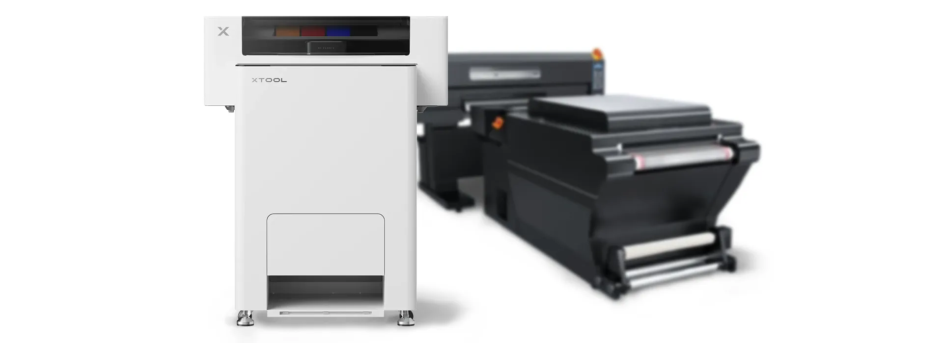 Compact xTool A3 DTF printer shown beside a larger commercial DTF printing system