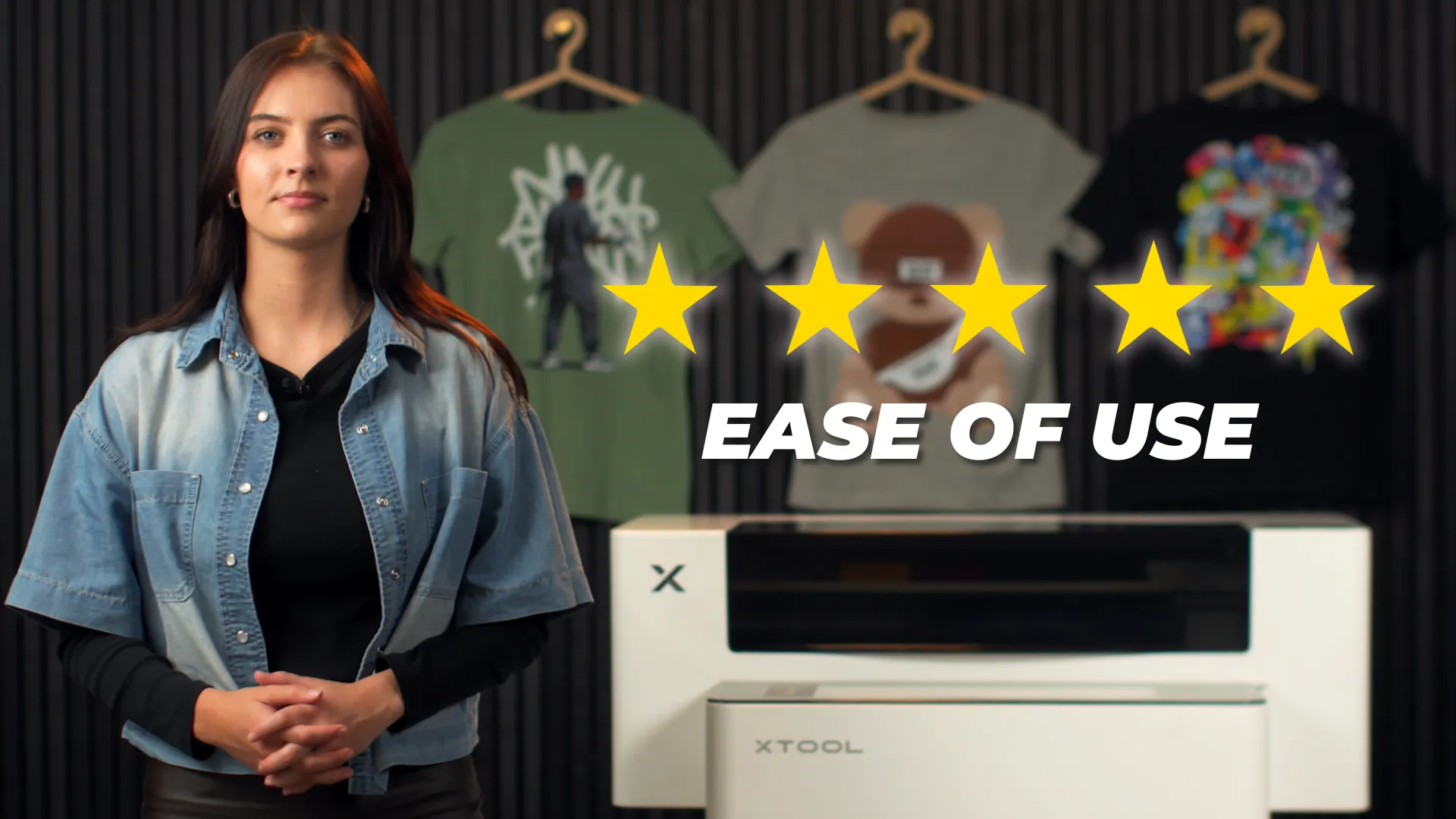 Presenter beside an xTool Apparel Printer with a five-star ease-of-use rating and printed shirts behind her