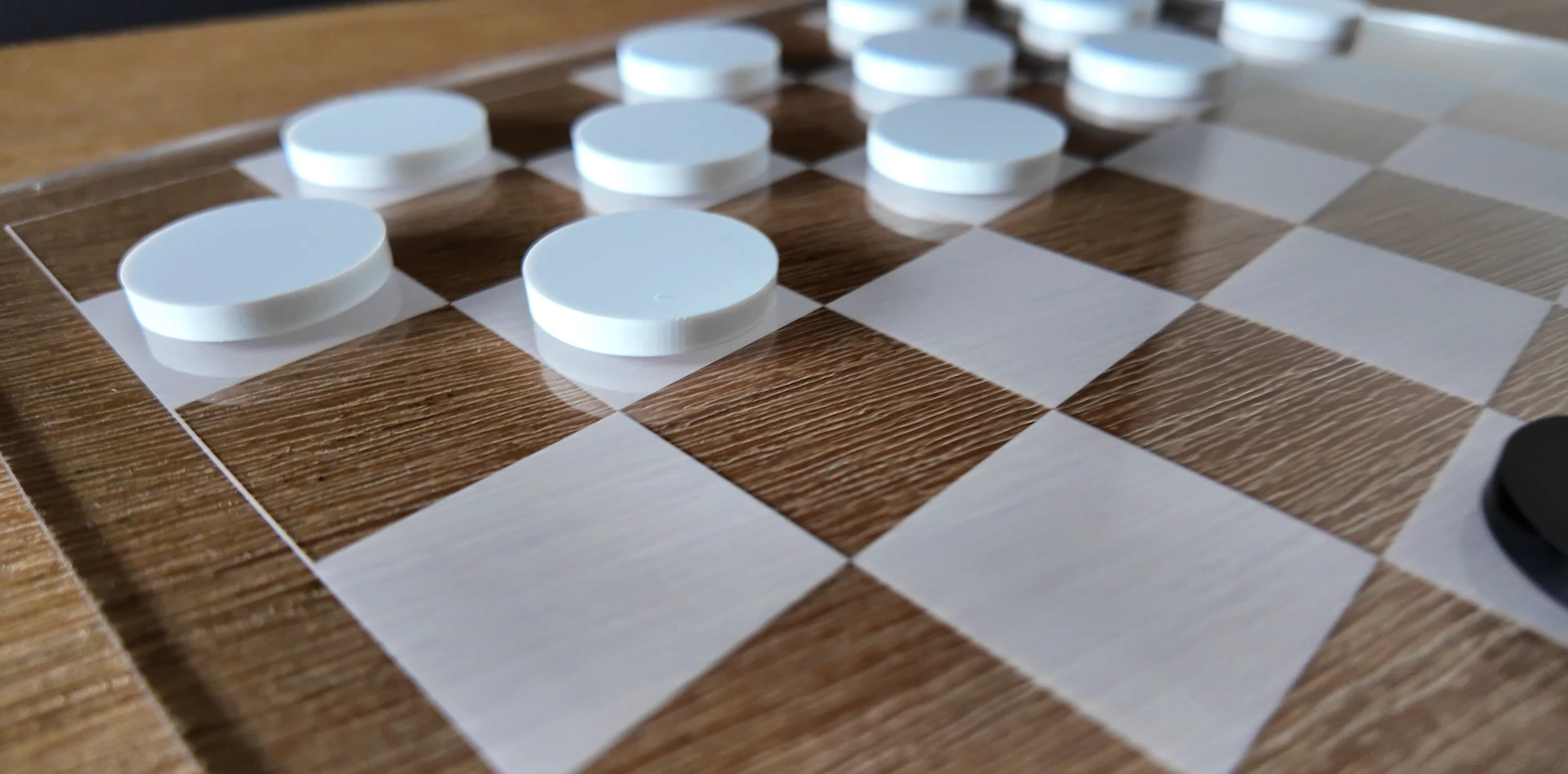 Finished clear acrylic checkers board with frosted squares and round playing pieces