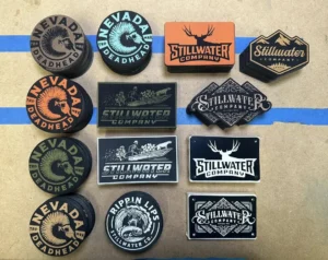Assorted engraved leather patches with circular and rectangular brand designs.