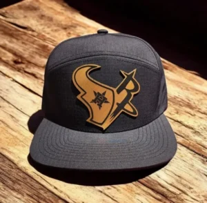 Black cap with a tan leather patch engraved with a bull logo.