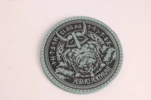 Round leather patch engraved with a detailed Viking design and decorative border.