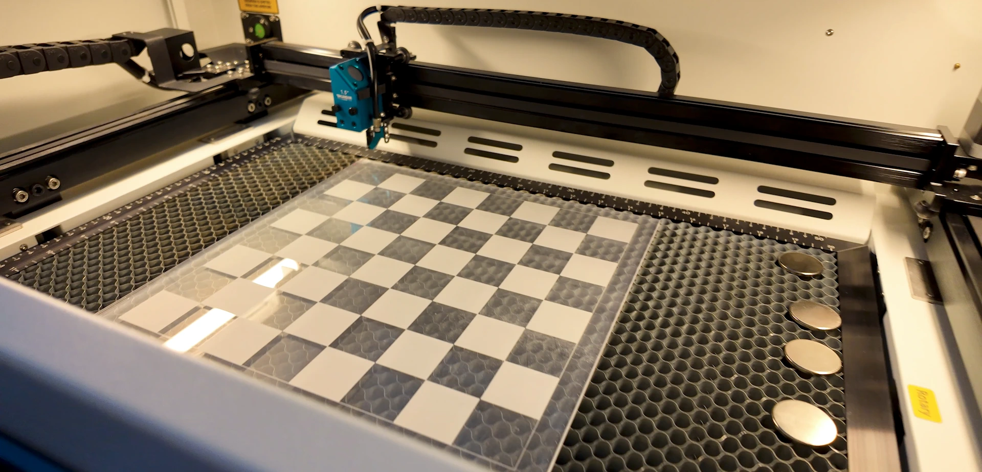 Acrylic checkers board being engraved inside a Thunder Bolt laser machine
