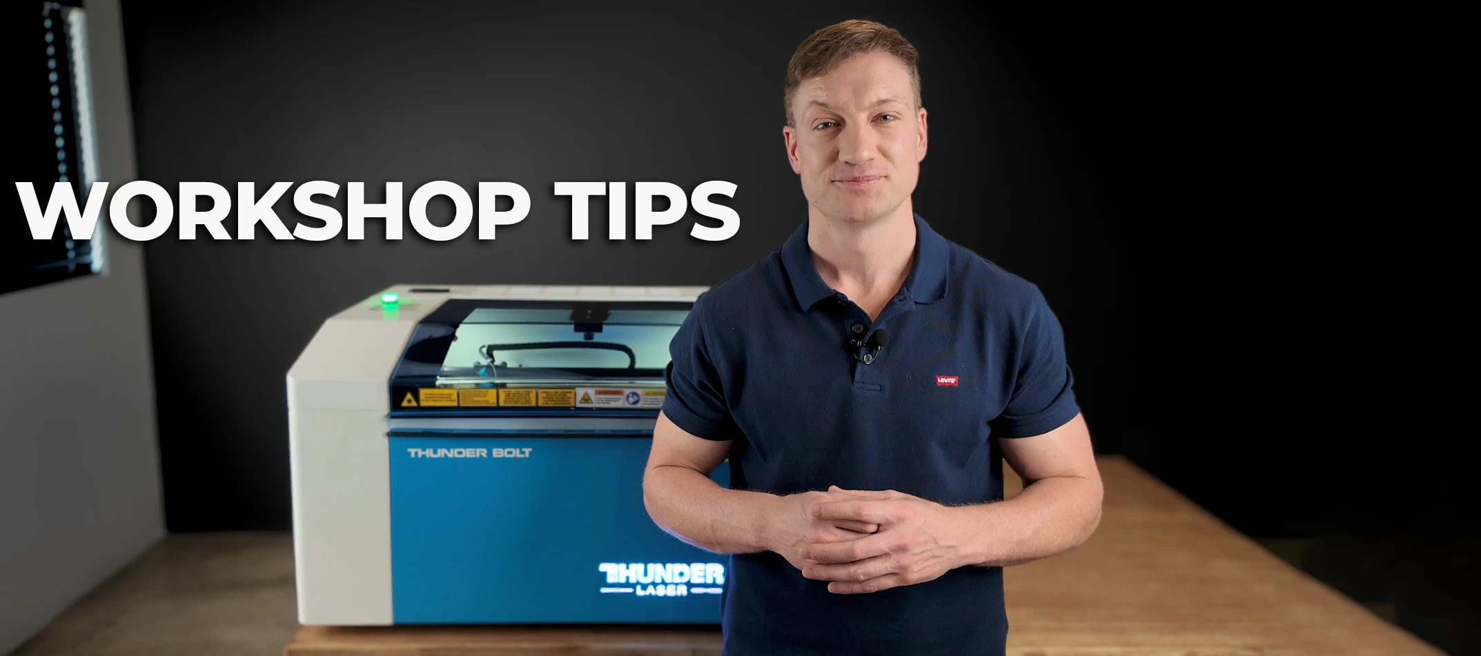 Presenter sharing workshop tips beside a Thunder Bolt laser engraving machine